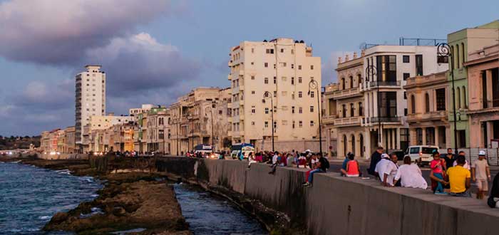 Personas sentadas en el Malecón