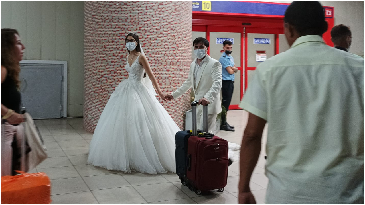 Novios llegan al aeropuerto de Cuba luciendo su traje de boda