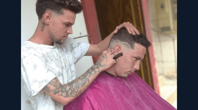 Barbero de Sancti Spíritus realizando un corte de cabello con dedicación y precisión.